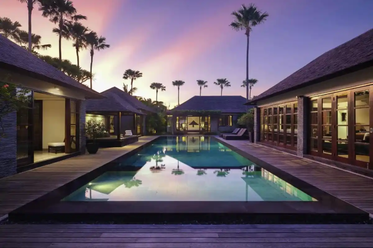 luxury private villa pool at sunset surrounded by palm trees